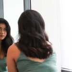 Carol: Cefaly has given me my life back a woman looks at her reflection in a bathroom mirror